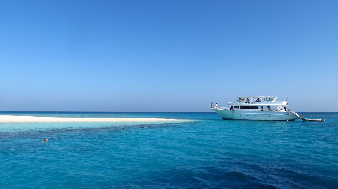 A guest relaxing on the Orange Bay sandbank with the Red Sea behind