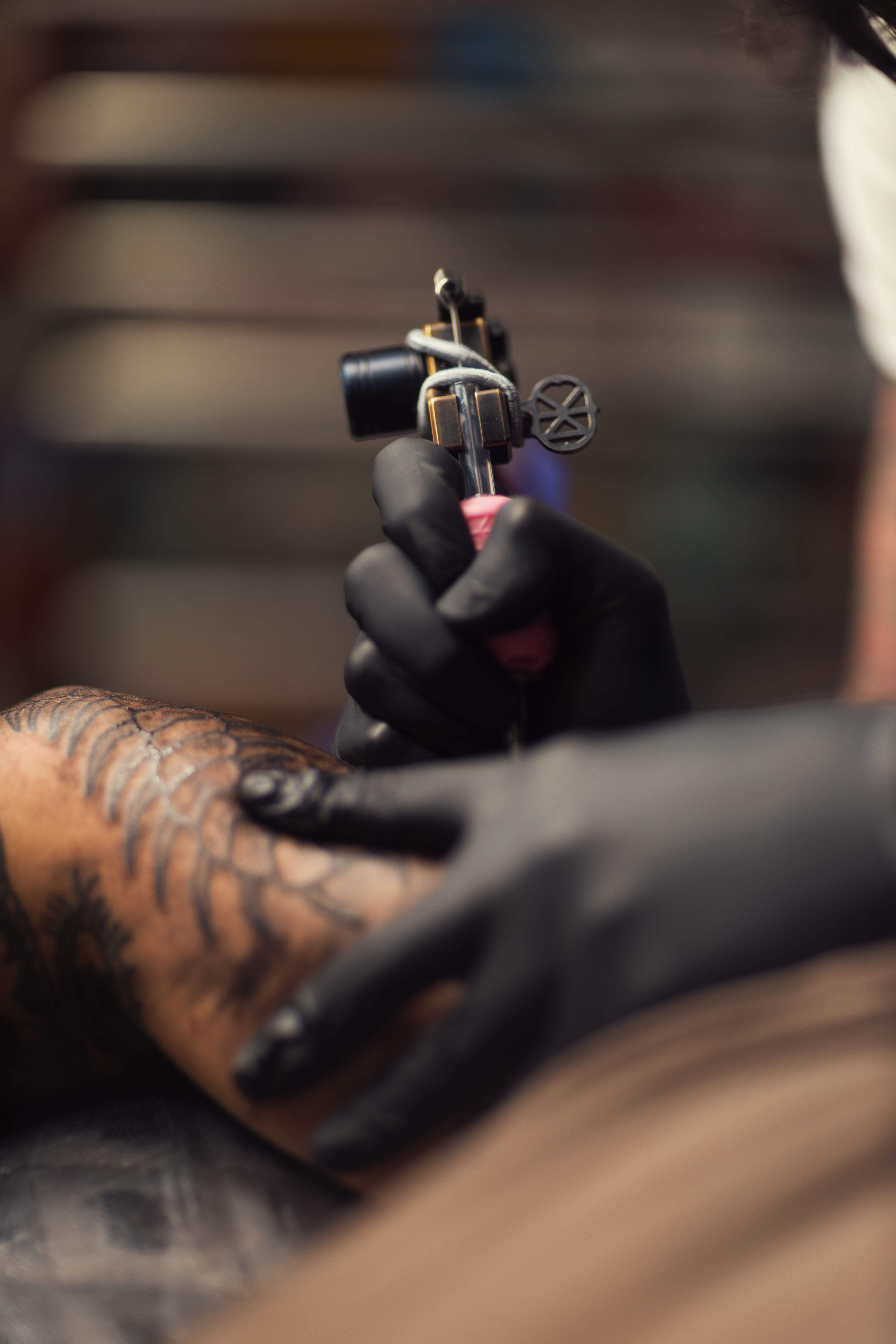 Close-up of an arm tattoo being finished at the studio.