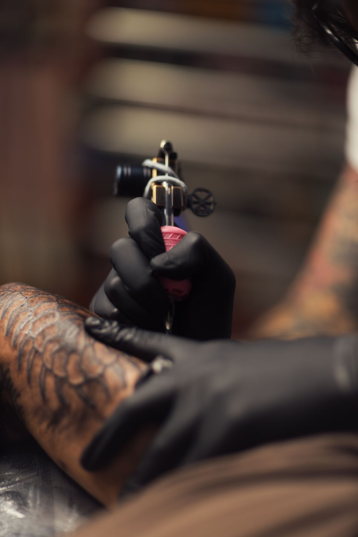 Close-up of an artist running a tattoo machine