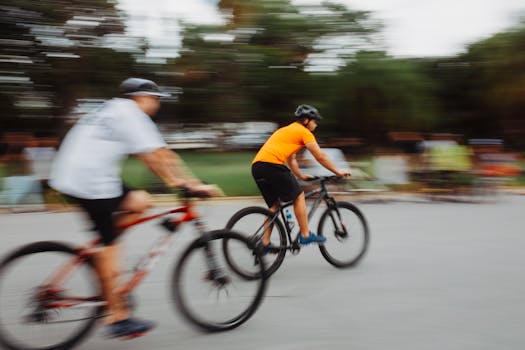 Two cyclists in motion blur racing on a city street, capturing speed and adrenaline.