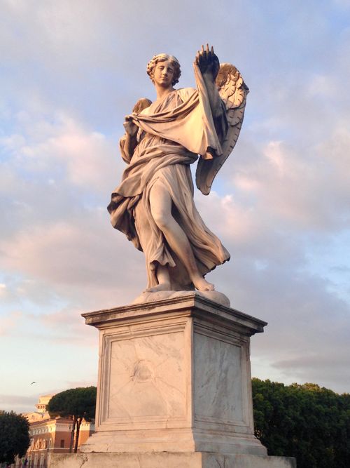Free A majestic angel statue on a pedestal under a serene sunset sky in Rome, Italy. Stock Photo