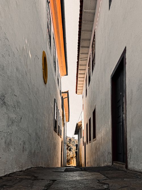 Free Captivating view of a narrow, sunlit alleyway between historic buildings. Stock Photo