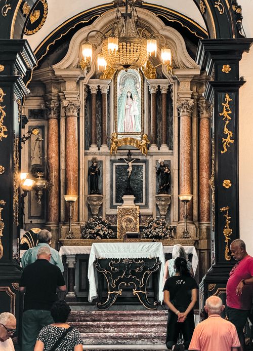 Free A beautifully ornate church interior with worshippers gathered in silent reflection. Stock Photo