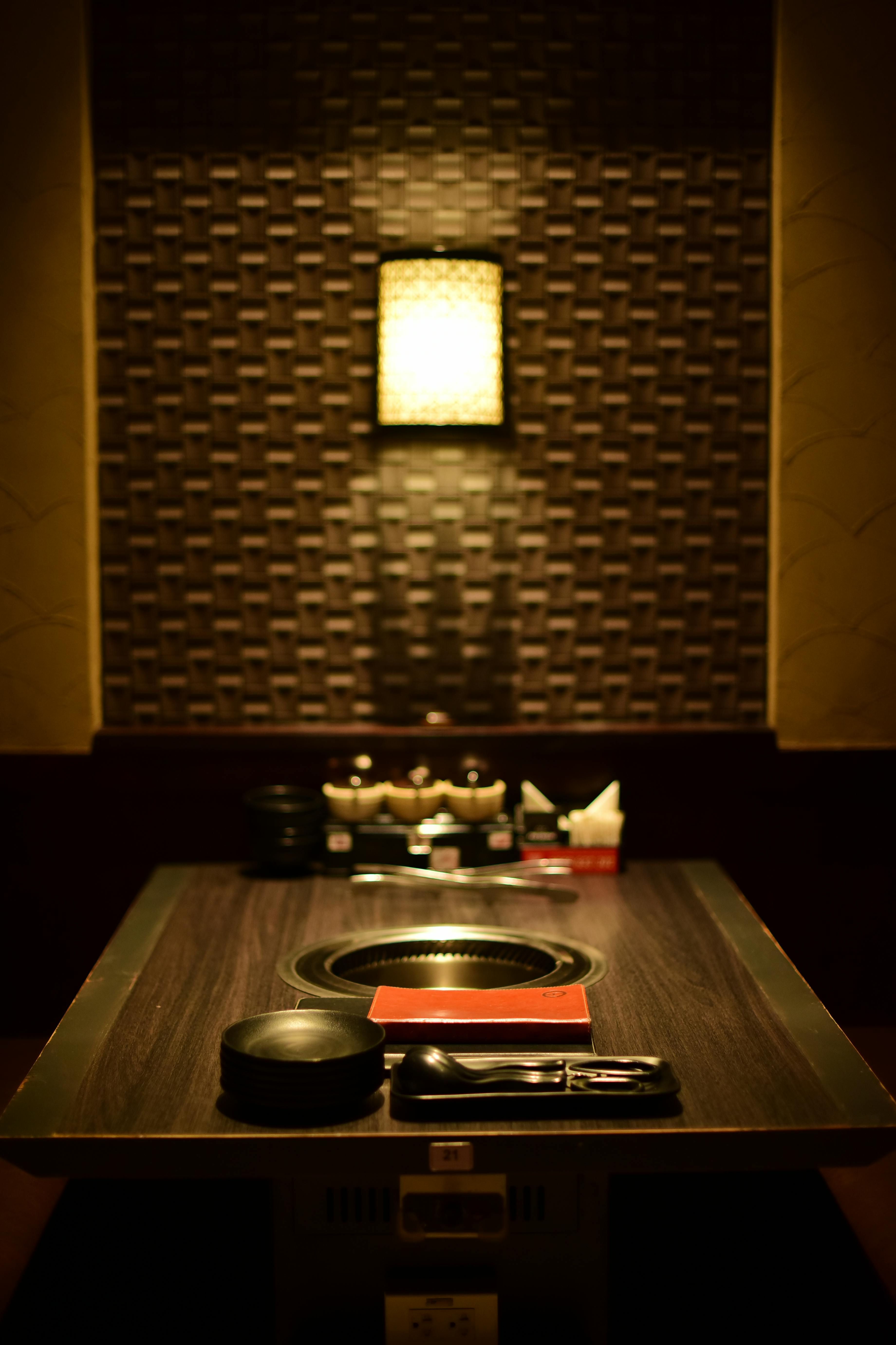 grátis Um ambiente intimista e aconchegante, com mesa de jantar japonesa e churrasqueira embutida. Foto profissional