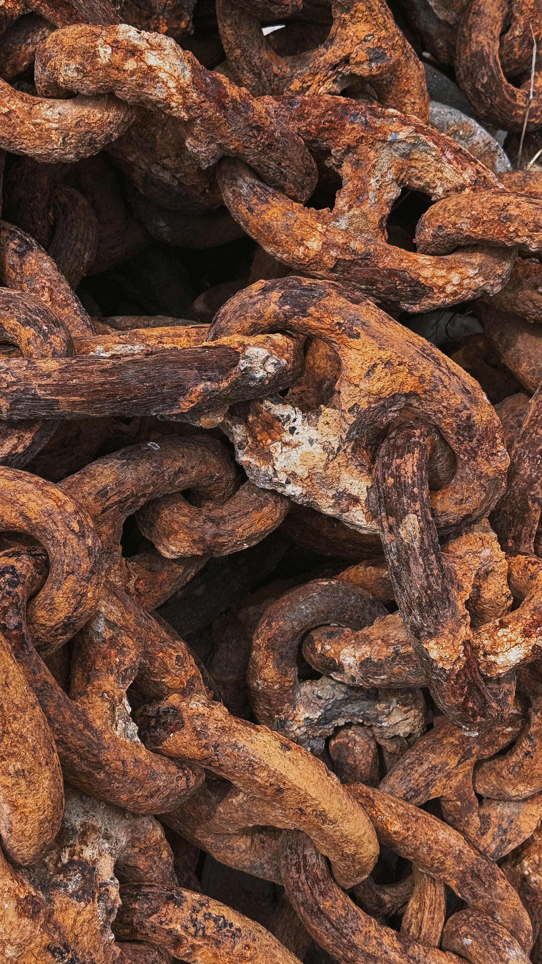 Detailed close-up of rusty chains forming a complex, abstract composition with rich textures.