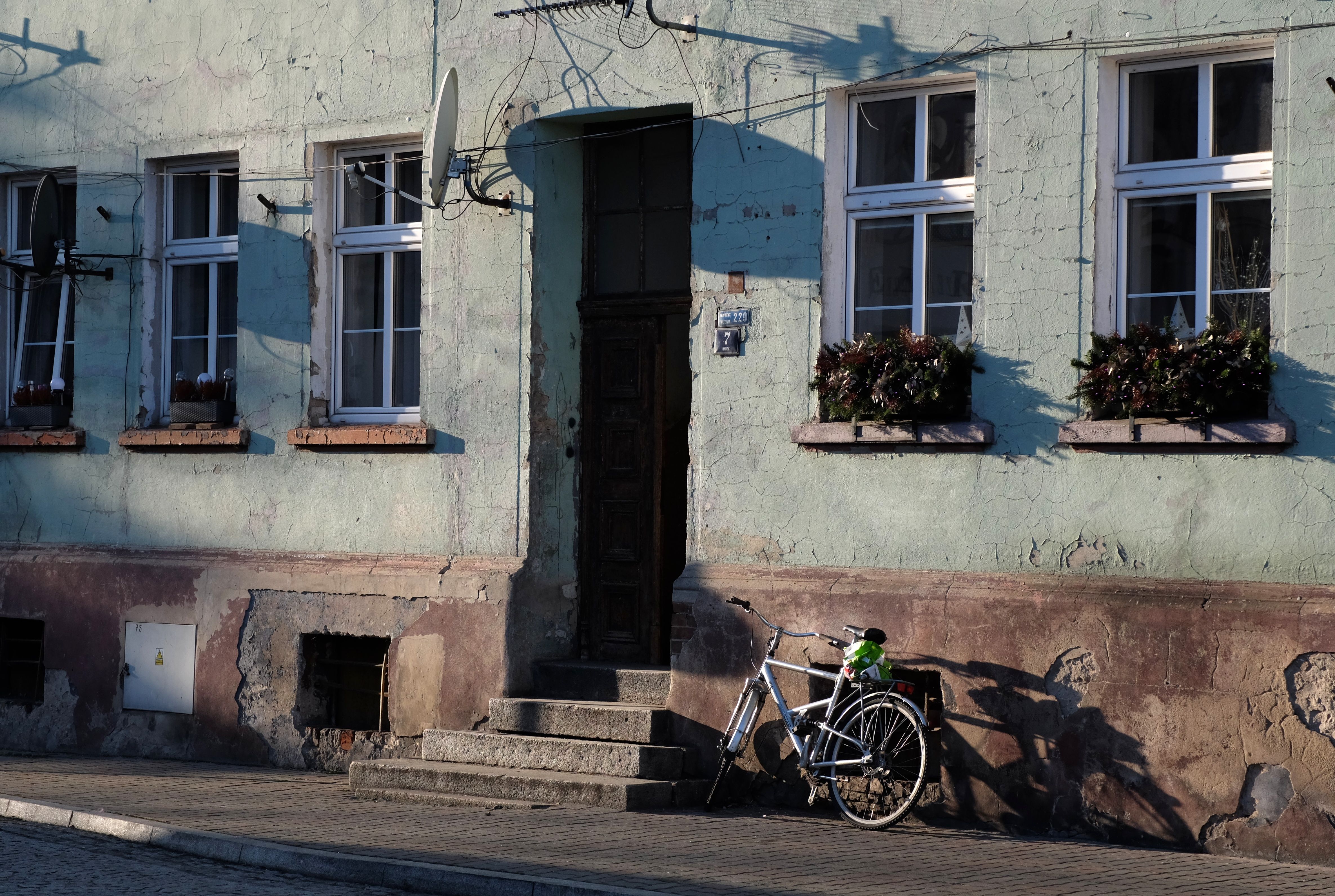 A quaint urban scene featuring an aged building facade with a bicycle parked nearby, ideal for retro aesthetics.