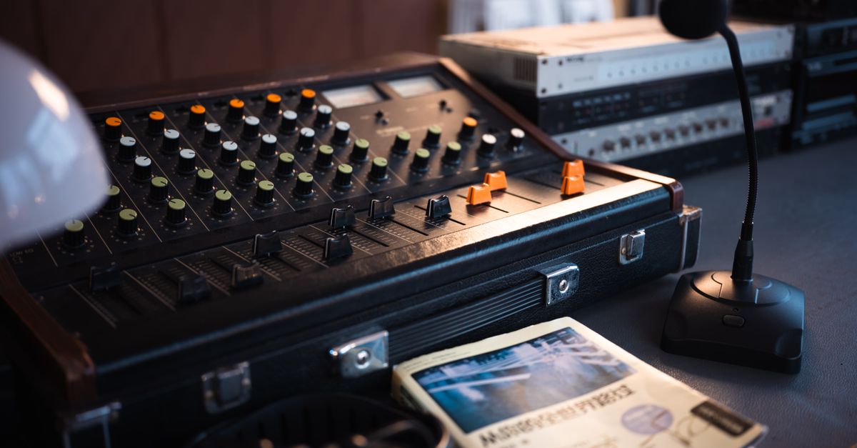 A recording studio setup in a barn, with microphones and a mixing board next to hay bales