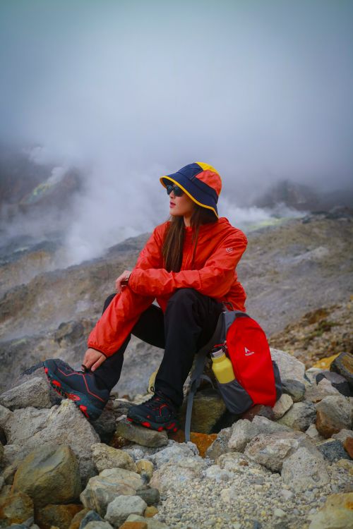 Free A woman in outdoor attire hiking through a misty mountain landscape in West Java, Indonesia. Stock Photo