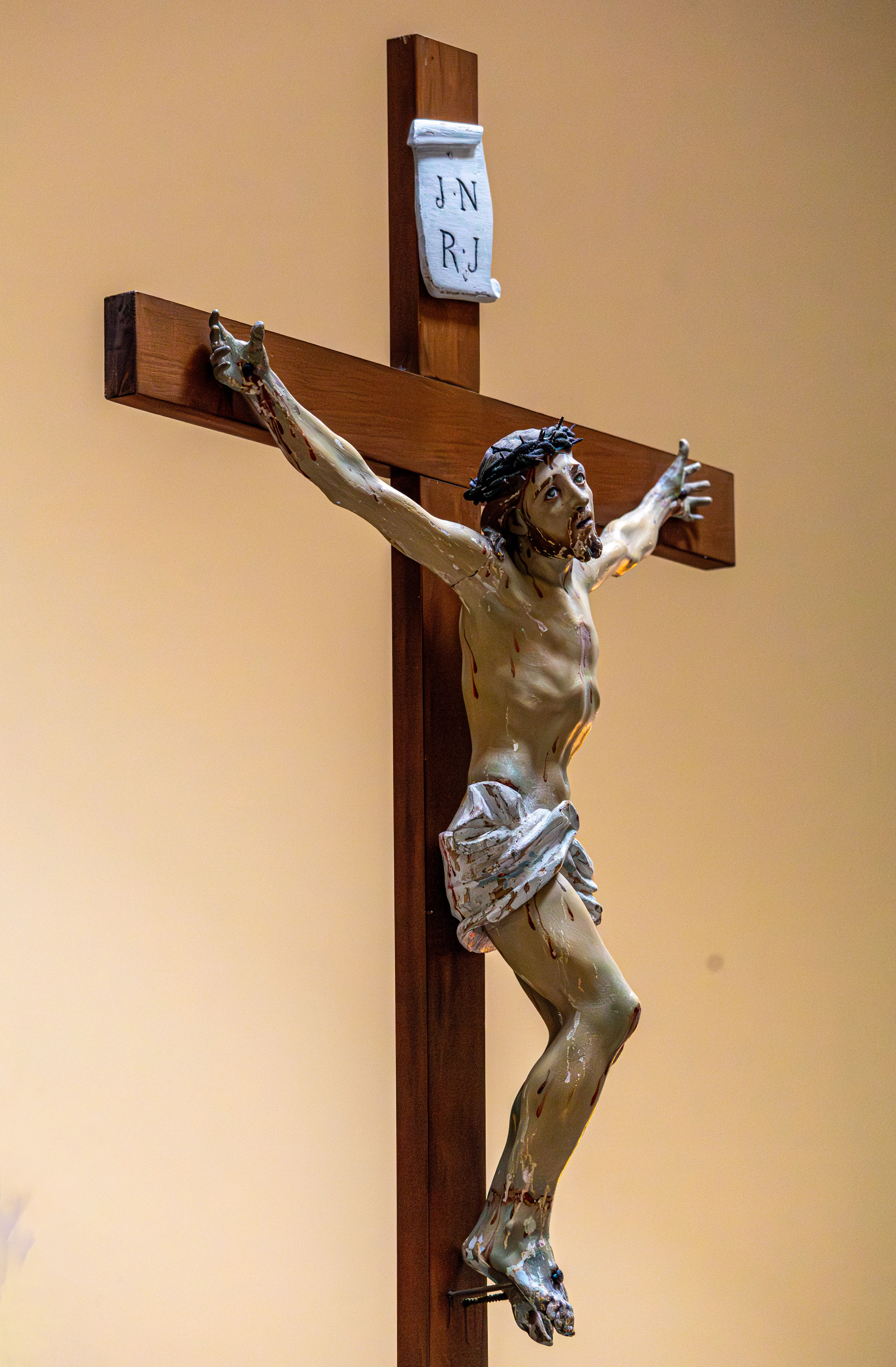 Detailed sculpture of Jesus Christ on a wooden cross, symbolizing Christianity.