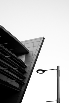 Black and white photo of modern architecture and streetlamp.