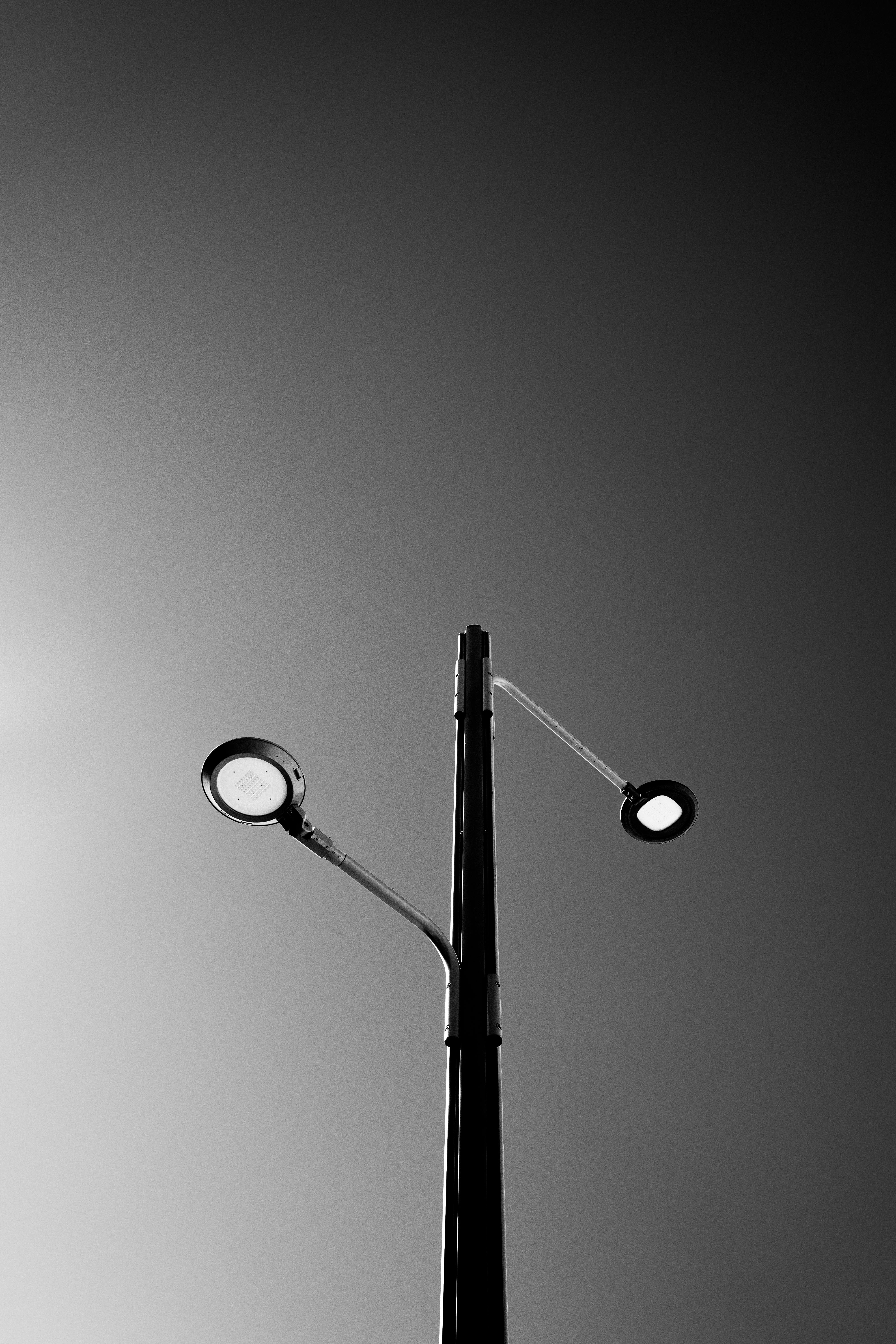 Gratis Foto minimalis hitam putih sebuah lampu jalan dengan latar langit. Foto Stok