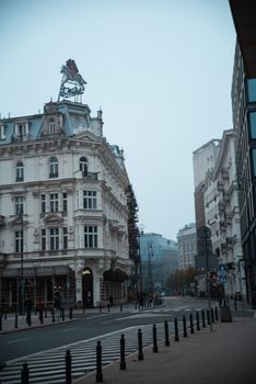 Explore the historic architecture of Warsaw on a foggy day, showcasing classic European style.
