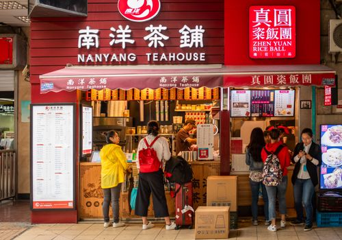 People gather at Nanyang Teahouse in Shanghai, showcasing urban street life and vibrant culture.