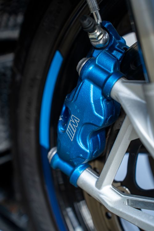 Free High-resolution image of a blue brake caliper on a motorcycle wheel, showcasing detailed engineering. Stock Photo