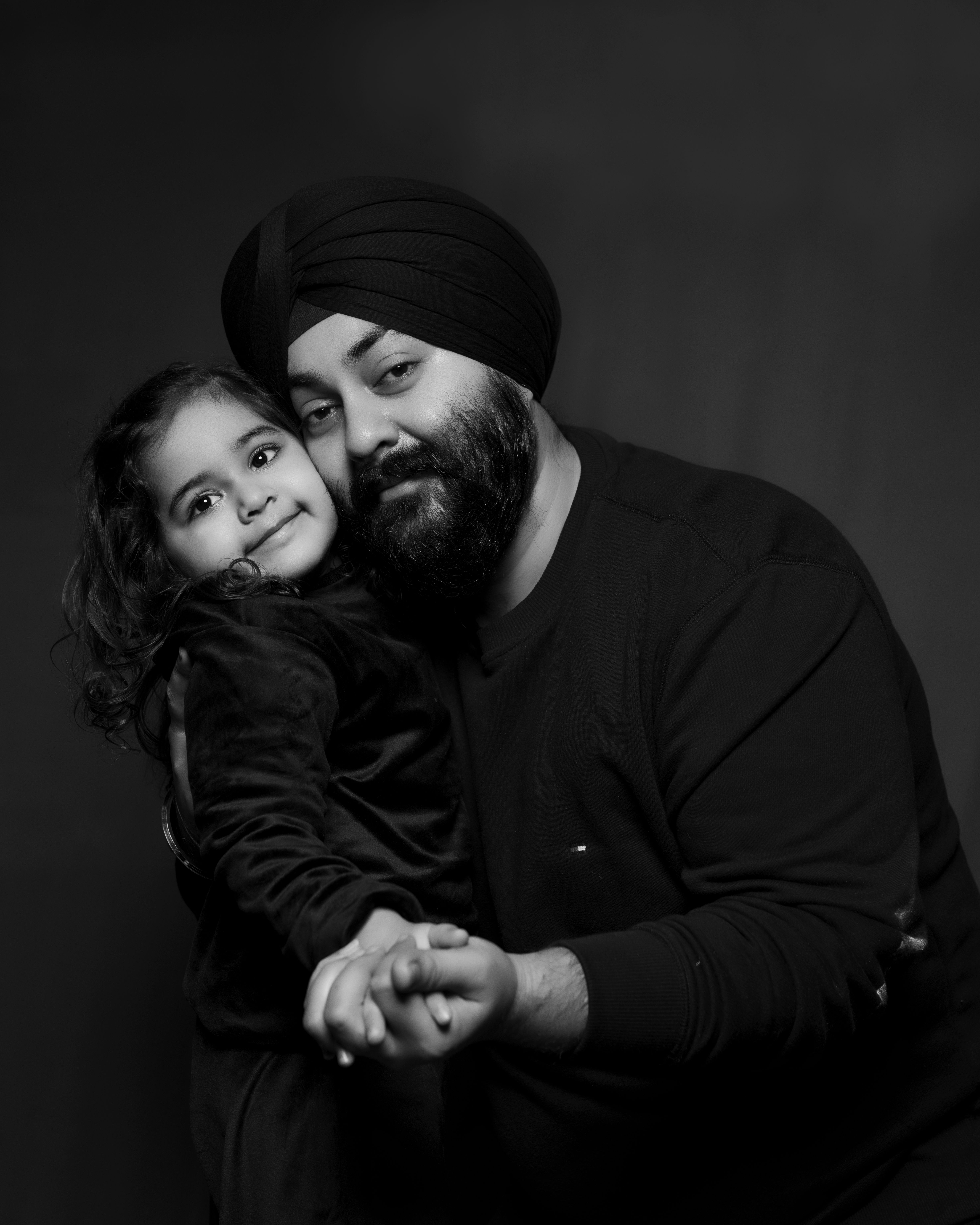 Black and white portrait of a father holding his young daughter's hand