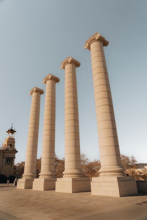 Free Four imposing stone columns under clear sky, symbolizing grandeur and timeless architecture. Stock Photo