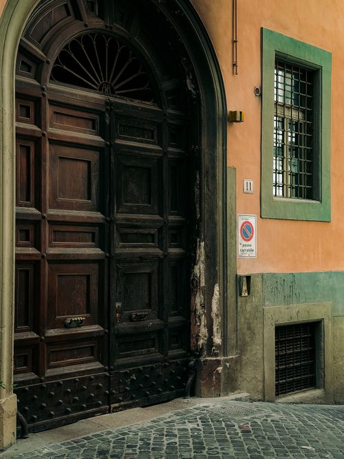 Free Ornate wooden door on a colorful building in Rome, Italy, showcasing classic architecture. Stock Photo