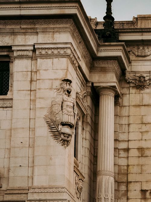 Free Close-up of intricate stone sculpture on historic Roman building exterior with classical columns. Stock Photo