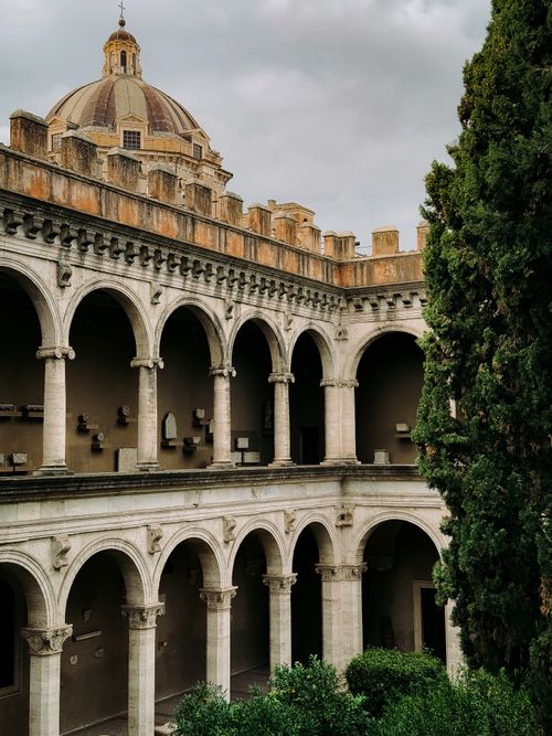 Free View of a historic Roman building with classic arches and lush greenery, capturing the essence of ancient architecture. Stock Photo