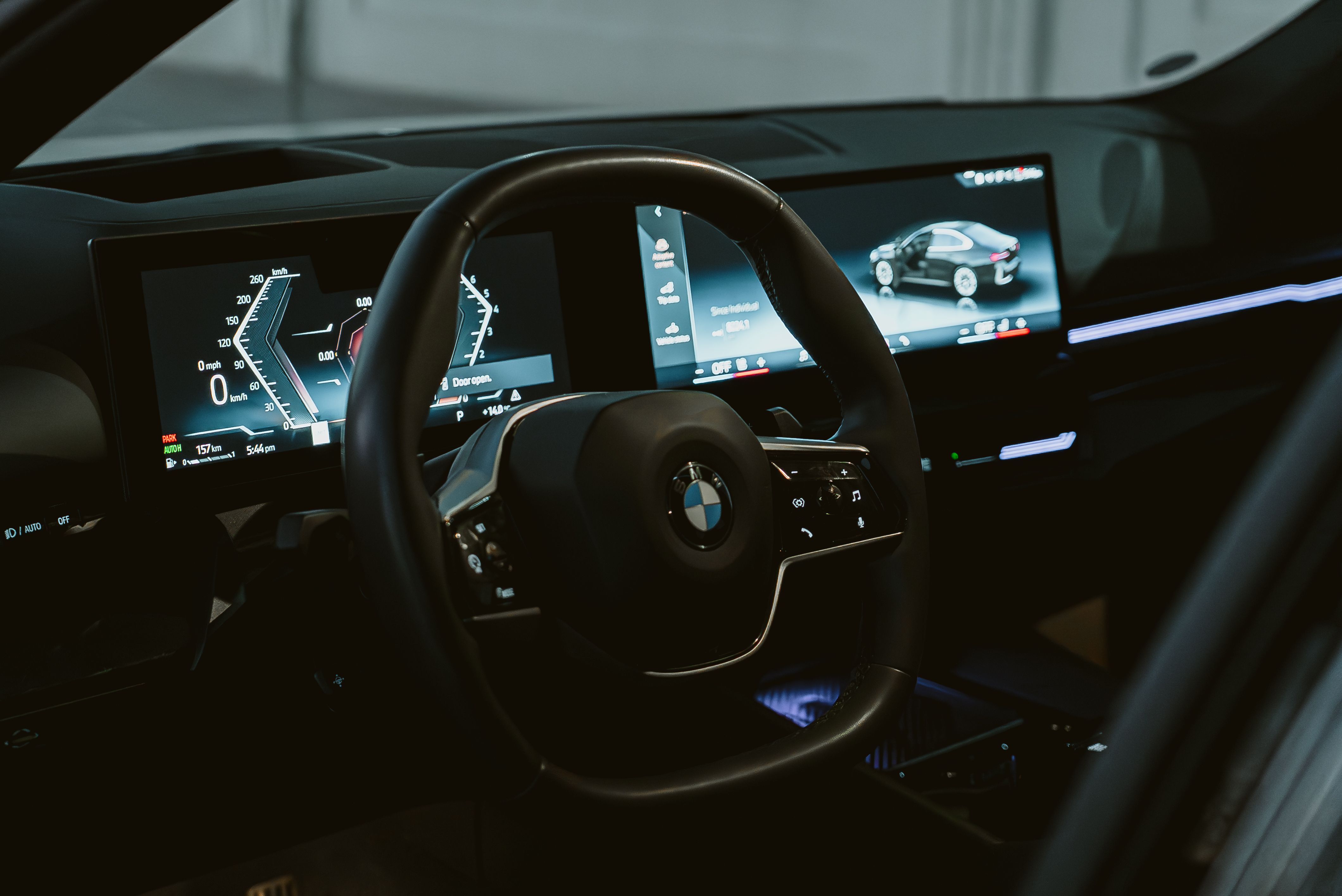 BMW interior close-up showing steering wheel and modern dashboard screens