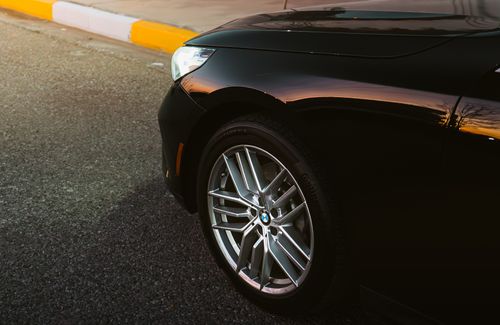 Free Close-up of a black car's wheel and body reflecting a sunset, roadside in Erbil, Iraq. Stock Photo