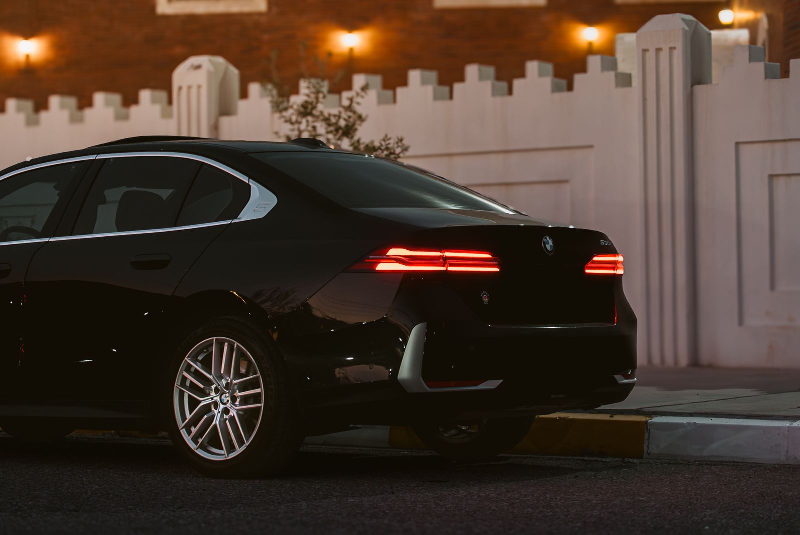 sleek black executive car by the roadside at night
