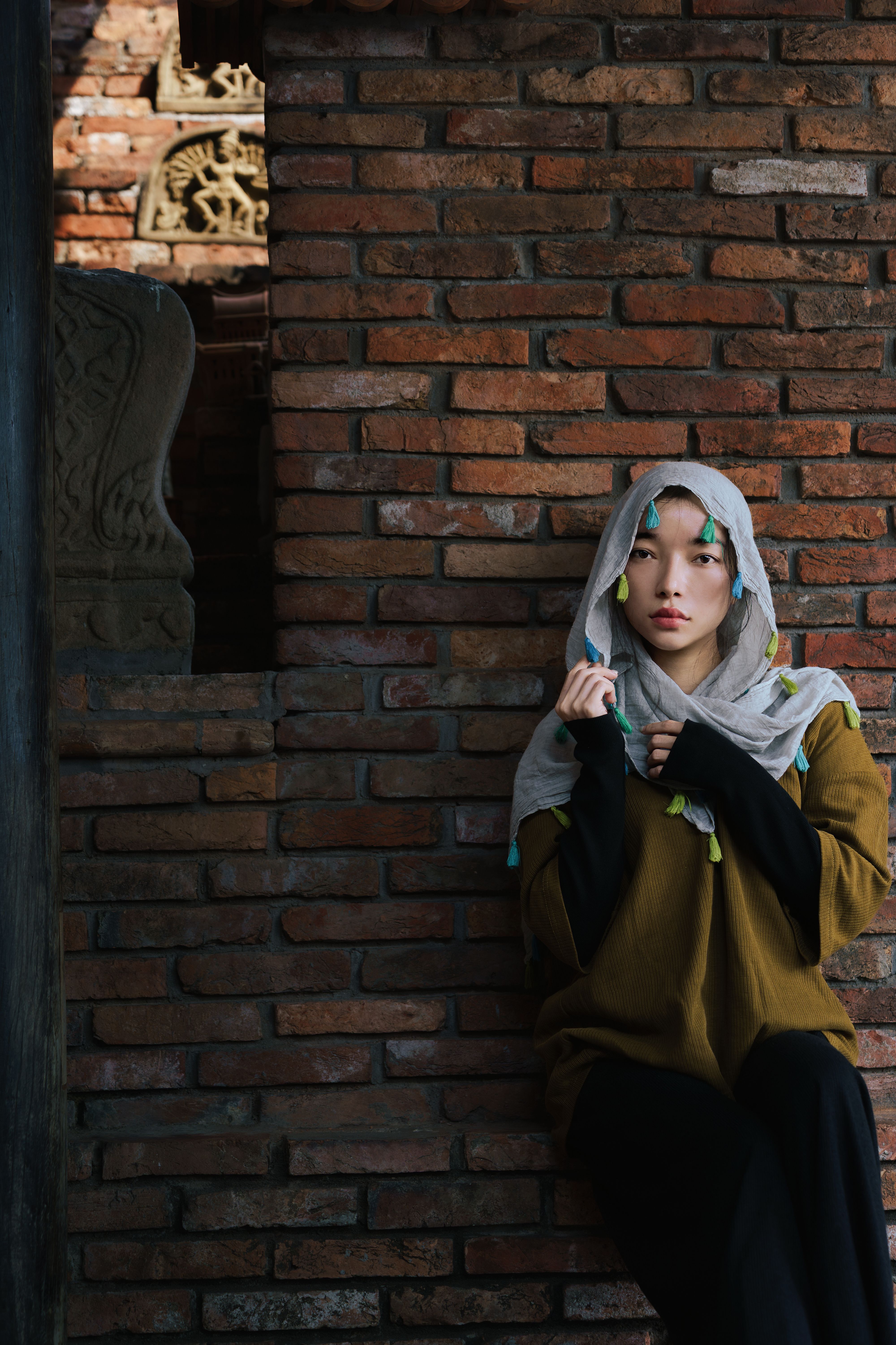 Portrait of a Woman in Traditional Attire by Brick Wall · Free Stock Photo