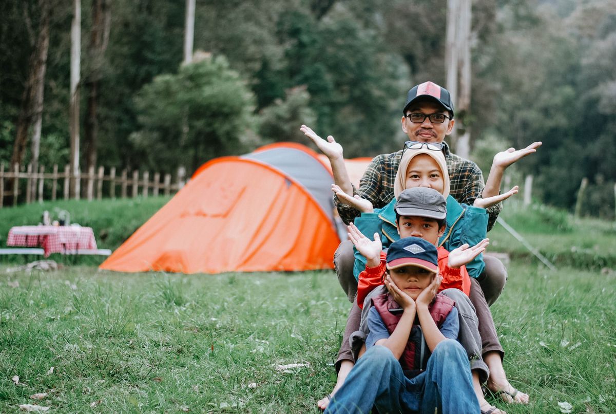 Happy family posing together at a forest campsite