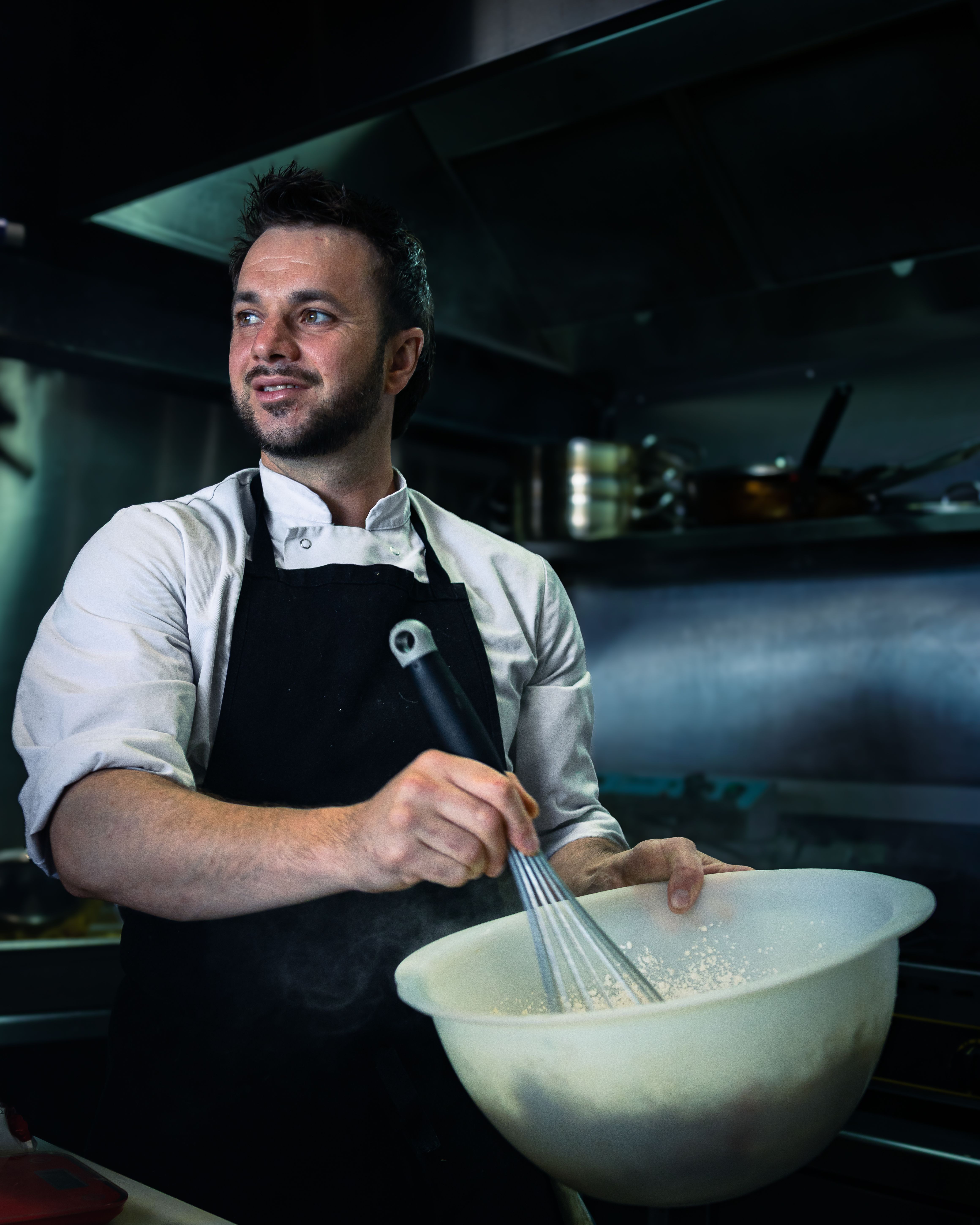 A chef prepares a dish in a contemporary kitchen in Bayonne, France, showcasing culinary artistry.