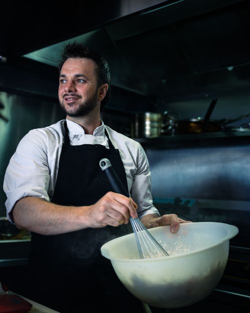 Free A chef prepares a dish in a contemporary kitchen in Bayonne, France, showcasing culinary artistry. Stock Photo