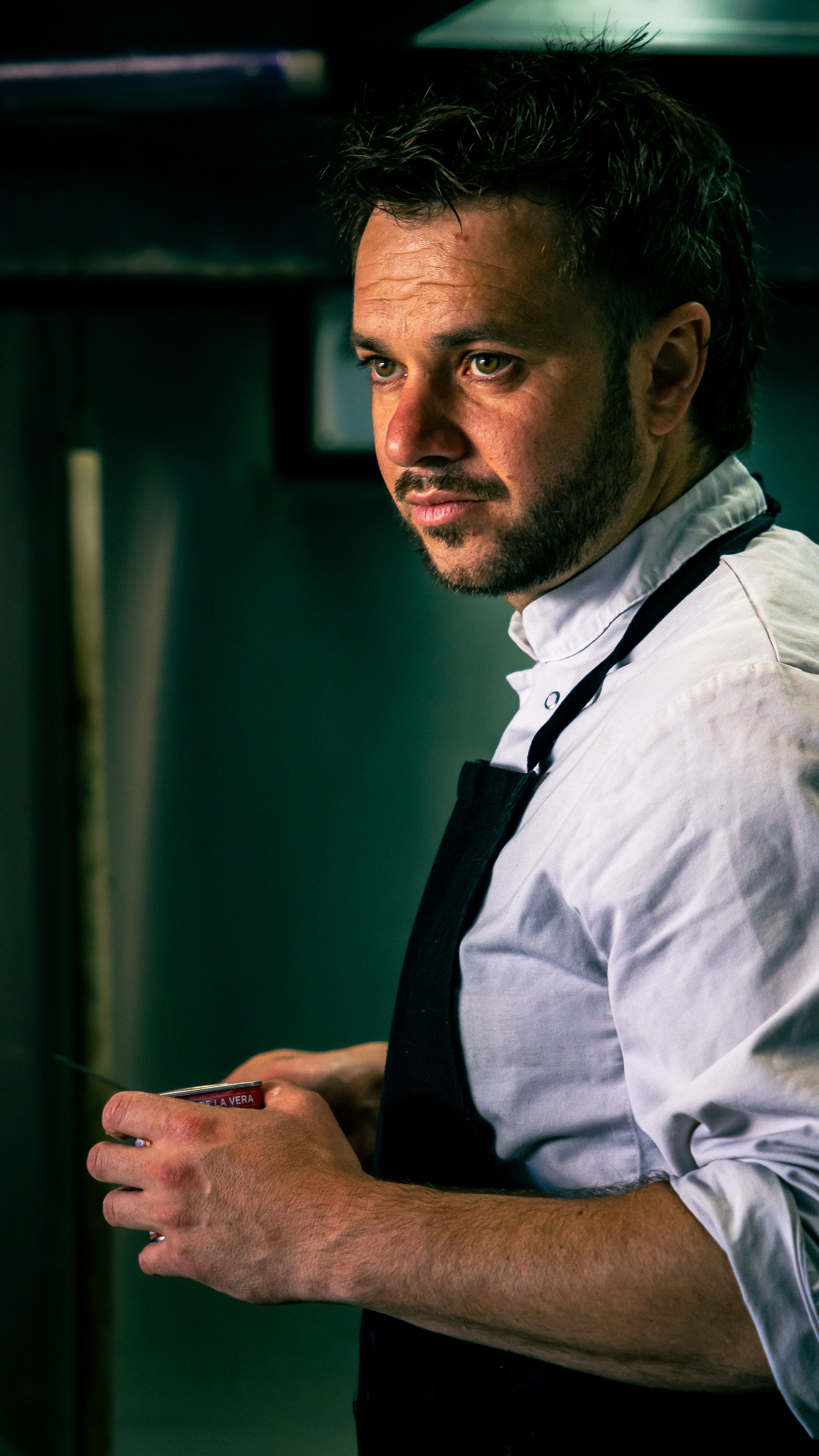 Chef in Bayonne kitchen focused intently on creating a gourmet dish.