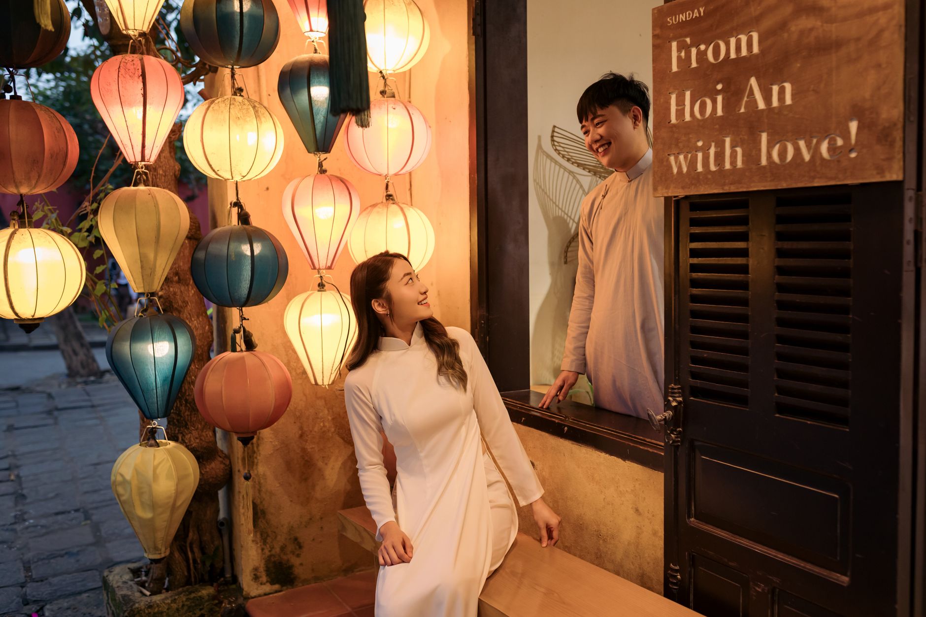 Charming couple sharing a moment in Hội An, surrounded by colorful lanterns at night.
