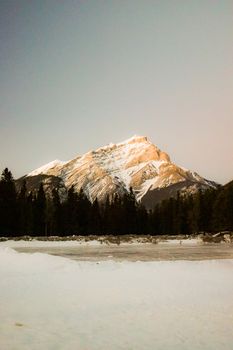 Breathtaking winter landscape featuring Mount Rundle in Banff National Park at sunset.