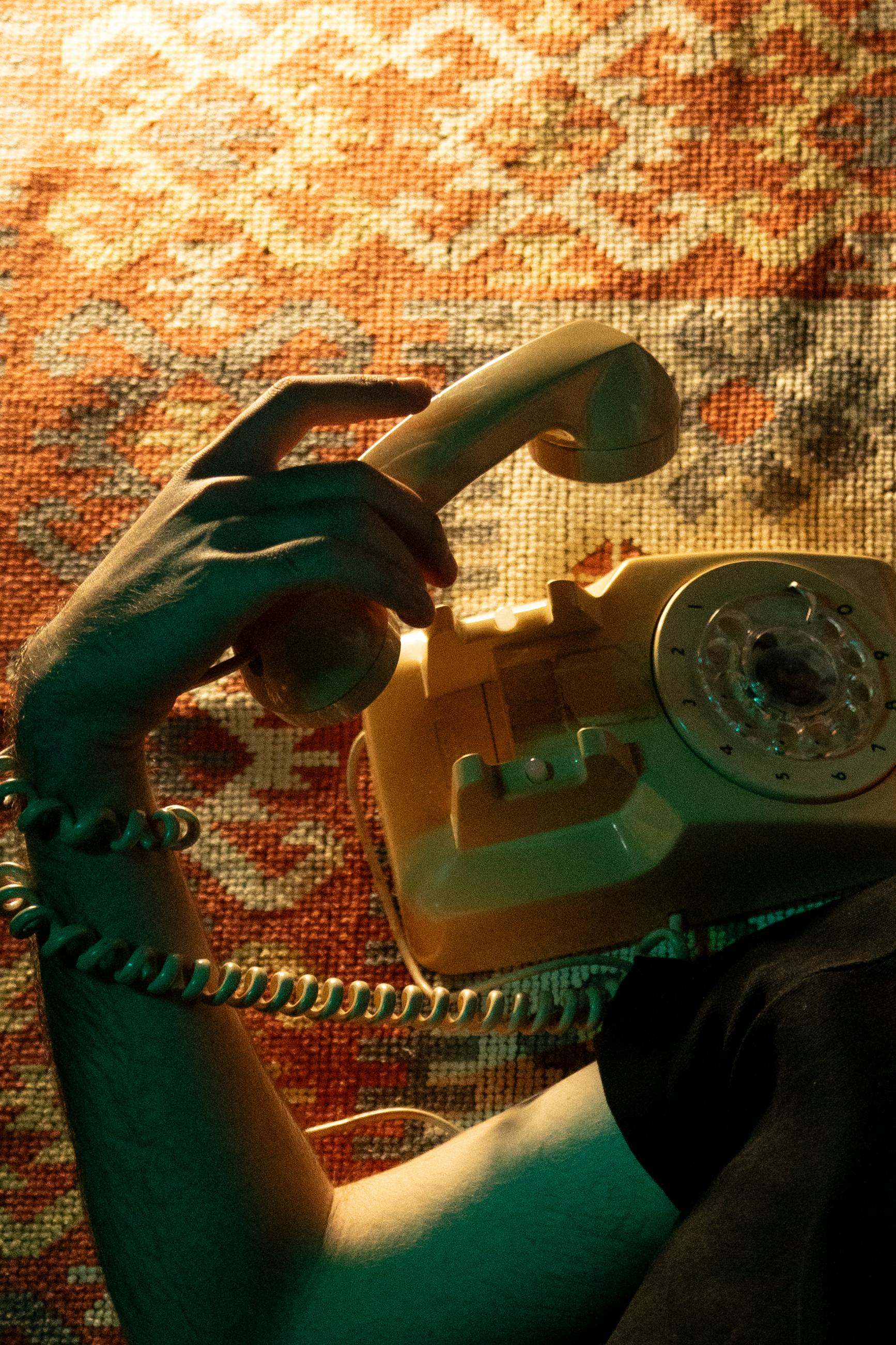 Gratis Kunstnerisk bilde av en roterende telefon med en hånd på et vintageteppe. Arkivbilde