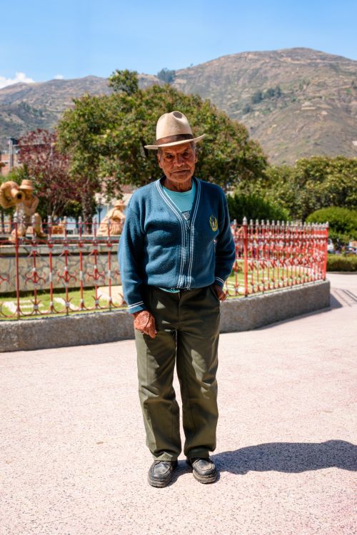 Free Elderly man wearing a traditional hat standing outdoors in Huaraz, Peru, with Andean mountains in the background. Stock Photo