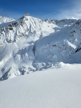 Breathtaking view of a snow-covered mountain range under a clear blue sky, perfect for winter and travel enthusiasts.