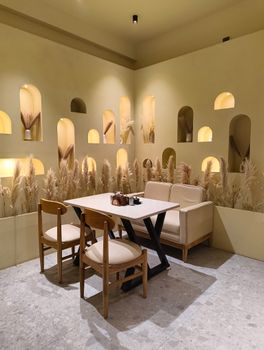 A warm and cozy minimalist cafe interior with natural decor and neutral tones.
