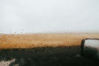 Glimpse of Icelandic landscape through a rain-dotted car window, creating serene and moody vibes.