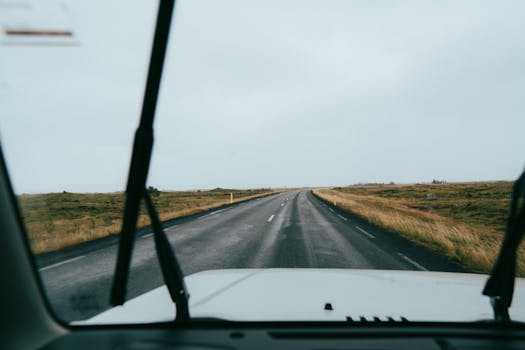 Explore the open Icelandic landscape through a car's windscreen on a scenic road trip.