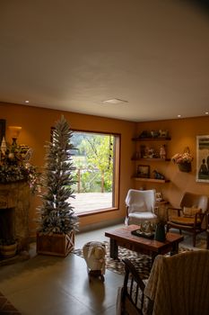 Warm and inviting living room decorated for Christmas with a view of the lush outdoors.