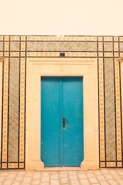 Free Capture of a vibrant blue door surrounded by intricate Tunisian tiles. Stock Photo