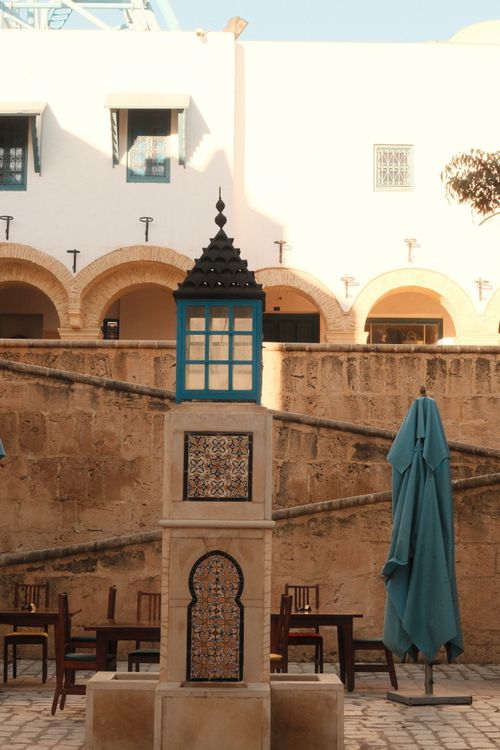 Free Tunisian courtyard showcasing traditional architecture and vibrant tiles, captured during daylight. Stock Photo