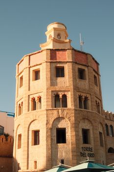 A sunlit view of a historic building in Tunisia with clear blue skies.