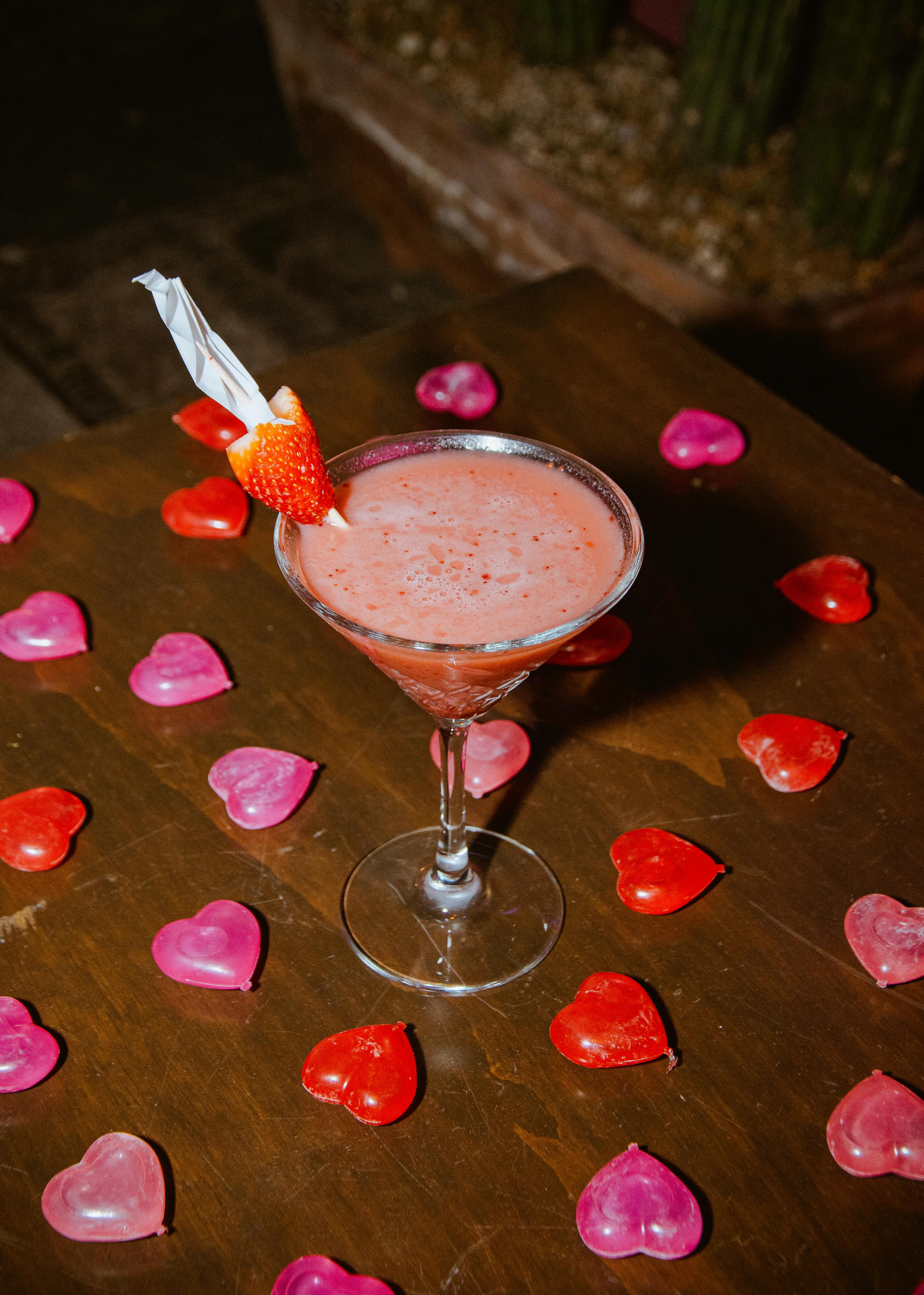 Strawberry cocktail with heart-shaped decorations, perfect for Valentine's Day.