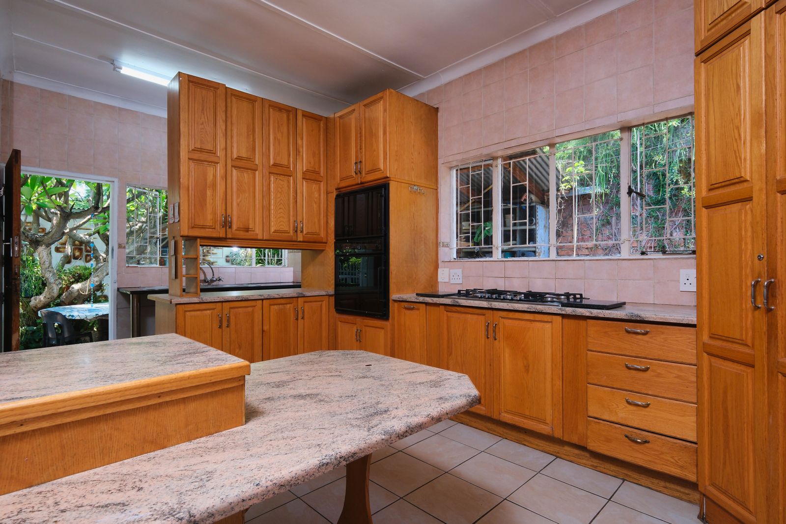 Warm rustic kitchen with wooden cabinets and garden view
