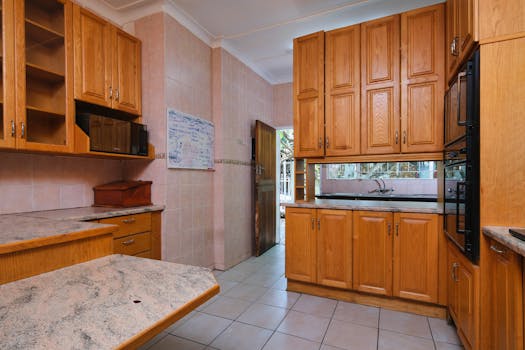 Modern kitchen interior featuring wooden cabinets and marble surfaces for a cozy home feel.