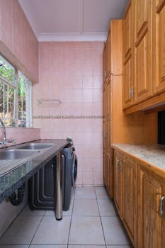 Bright kitchen with wooden cabinetry and laundry appliances.
