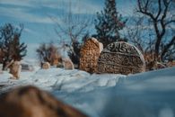Ancient tombstones covered in snow create a serene winter scene in Hani, Diyarbakır, Türkiye.