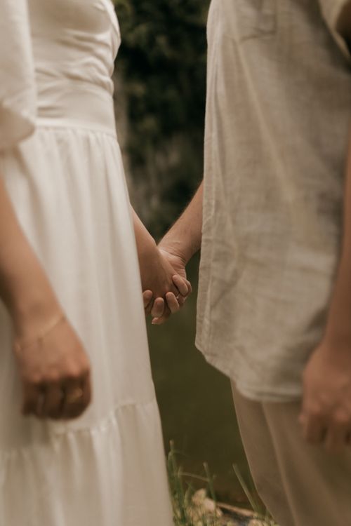 Free A couple sharing a romantic moment holding hands outdoors, symbolizing love and connection. Stock Photo