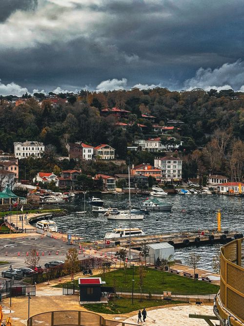 Free A picturesque view of the Bosphorus waterfront in İstanbul with houses and boats under a cloudy sky. Stock Photo